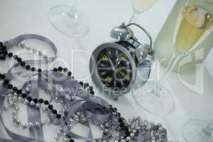 Champagne with alarm clock and glass on white background