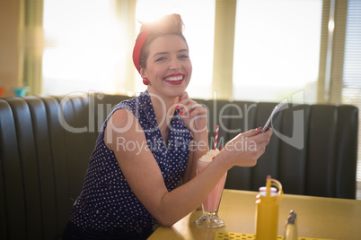 Woman using mobile phone in restaurant