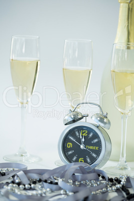 Champagne with alarm clock and glass on white background