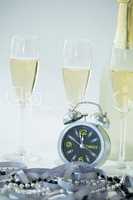 Champagne with alarm clock and glass on white background