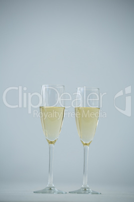 Two champagne flutes against white background