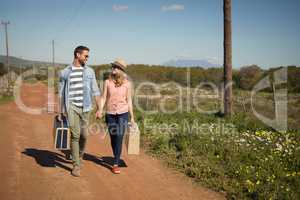 Couple walking with their luggage on a sunny day