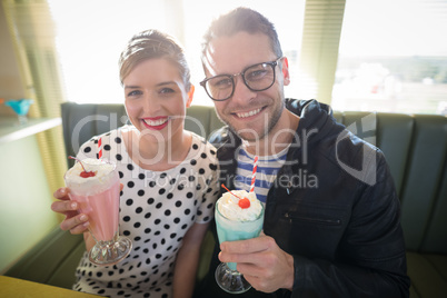 Couple having milkshake in restaurant