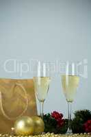 Champagne flute and christmas decoration against white background