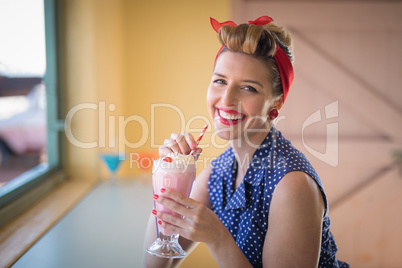 Woman having milkshake in restaurant