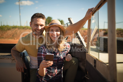 Couple using mobile phone in a car