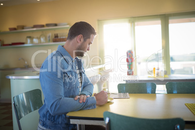 Man reading newspaper while having coffee