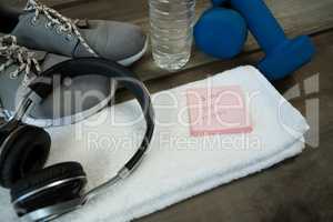 Shoes, headphones, water bottle, towel, dumbbell and stick notes