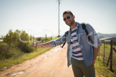 Man hitchhiking on a sunny day
