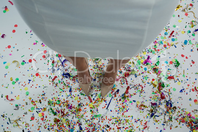 Woman standing wearing beige heels standing on the confetties