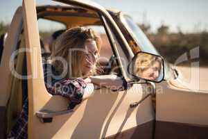 Woman standing near a car with door opened