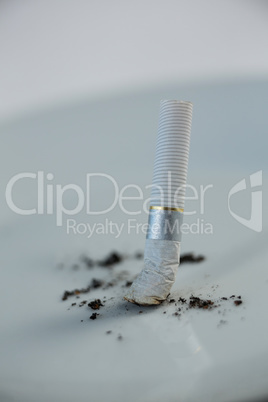 Single cigarette butt with ash isolated on white background