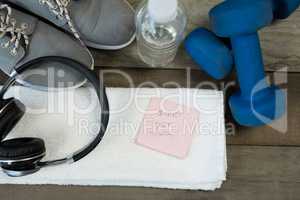 Shoes, headphones, water bottle, towel, dumbbell and stick notes