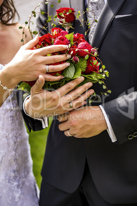 Bride and groom holding bridal bouquet