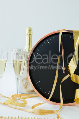 Champagne with clock and glass on white background