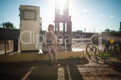 Woman sitting at petrol pump station