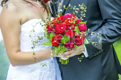 Bride and groom holding bridal bouquet