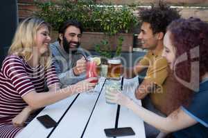 Friends toasting glass of drinks in bar
