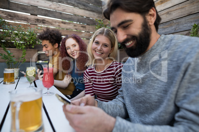 Friends using mobile phone in bar