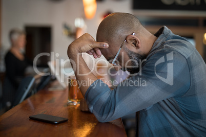 Depressed man standing at counter