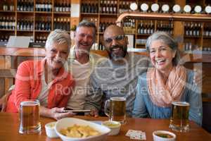 Happy friends sitting together at bar