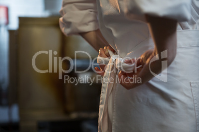 Female chef tying her uniform