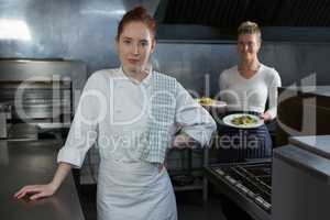 Female chefs holding food plates