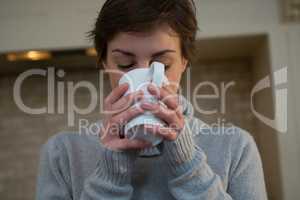 Woman having cup of coffee in kitchen