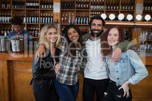 Friends standing together with arm around at counter