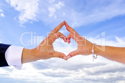 Bridal couple shapes heart with hands