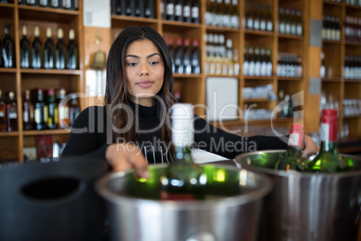 Waitress looking at bucket of beer bottle