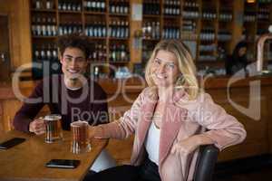 Happy couple having glass of beer in bar