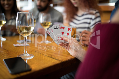 Group of friends playing cards in bar