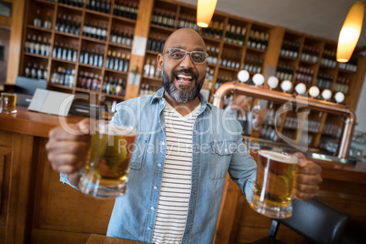 Smiling man having glasses of beer in restaurant