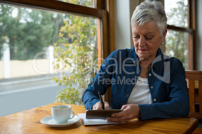 Senior woman writing in a diary