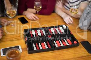 Friends playing backgammon while having glass of wine