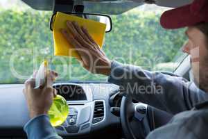 Auto service staff cleaning rear view mirror
