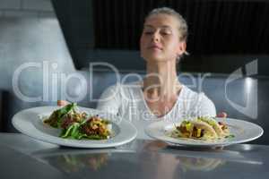 Female chef holding food plate