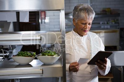 Female chef holding digital tablet