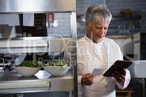 Female chef holding digital tablet