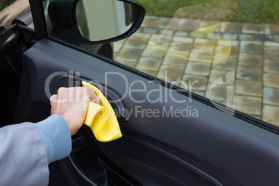 Auto service staff cleaning car door