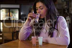 Woman drinking tequila shot