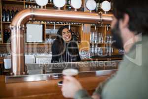 Smiling waitress talking to man at counter