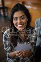 Beautiful woman holding cards in bar