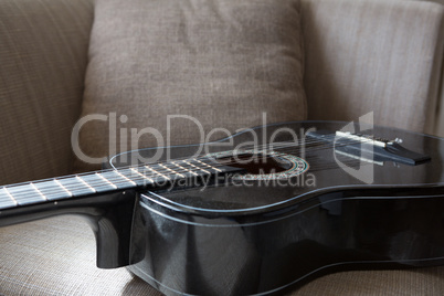 Guitar kept on sofa in living room