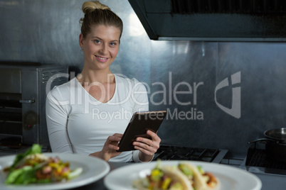 Female chef using digital tablet