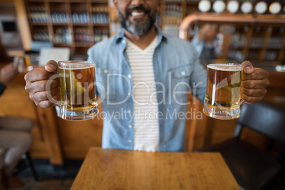 Smiling man having glasses of beer in restaurant