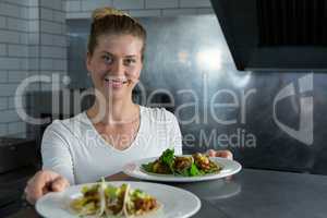 Female chef holding food plate