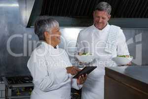 Male and female chef interacting with each other