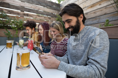 Friends using mobile phone in bar